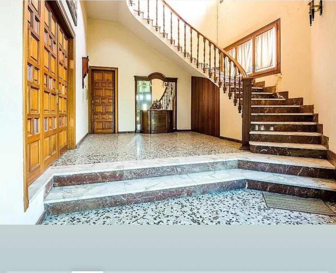 Recibidor con escalera de mármol